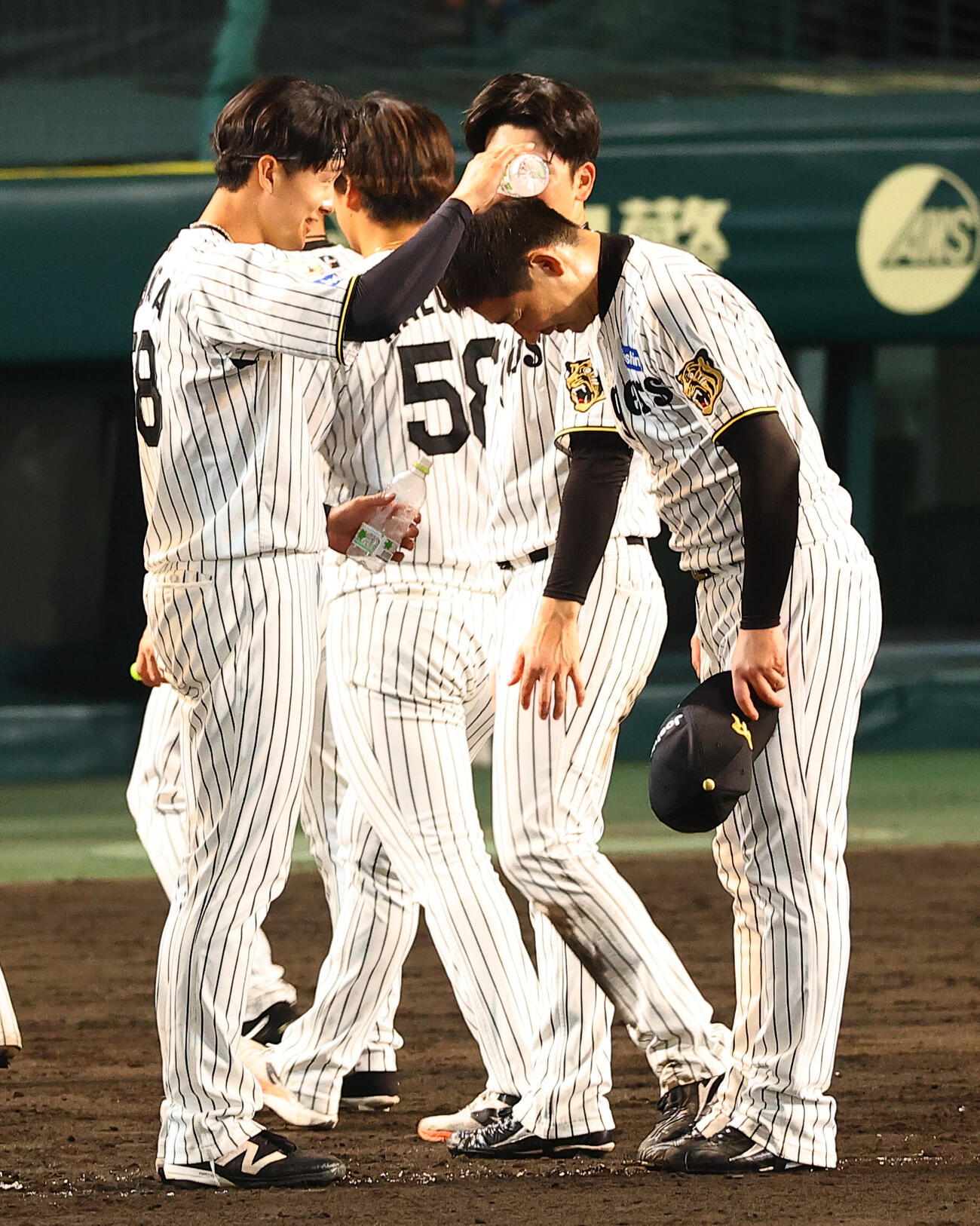 阪神対中日　今シーズン初勝利の岩崎優（右）は小幡竜平からのウオーターシャワーを浴びる（撮影・上田博志）