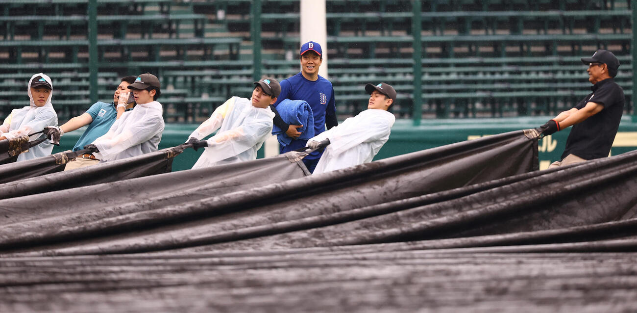 阪神対中日　中日柳裕也（中央）は作業が行われる甲子園球場のグラウンドを歩く（撮影・上田博志）