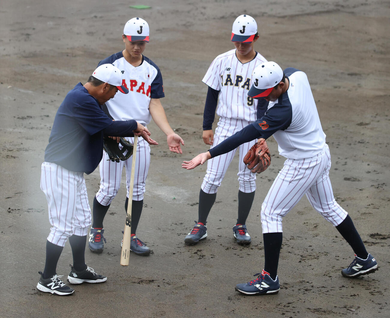 大島公一コーチ（左）は法大・井上和輝（右端）、慶大・林純司（中央左）、中京大・鈴木湧陽にアドバイスする（撮影・柴田隆二）
