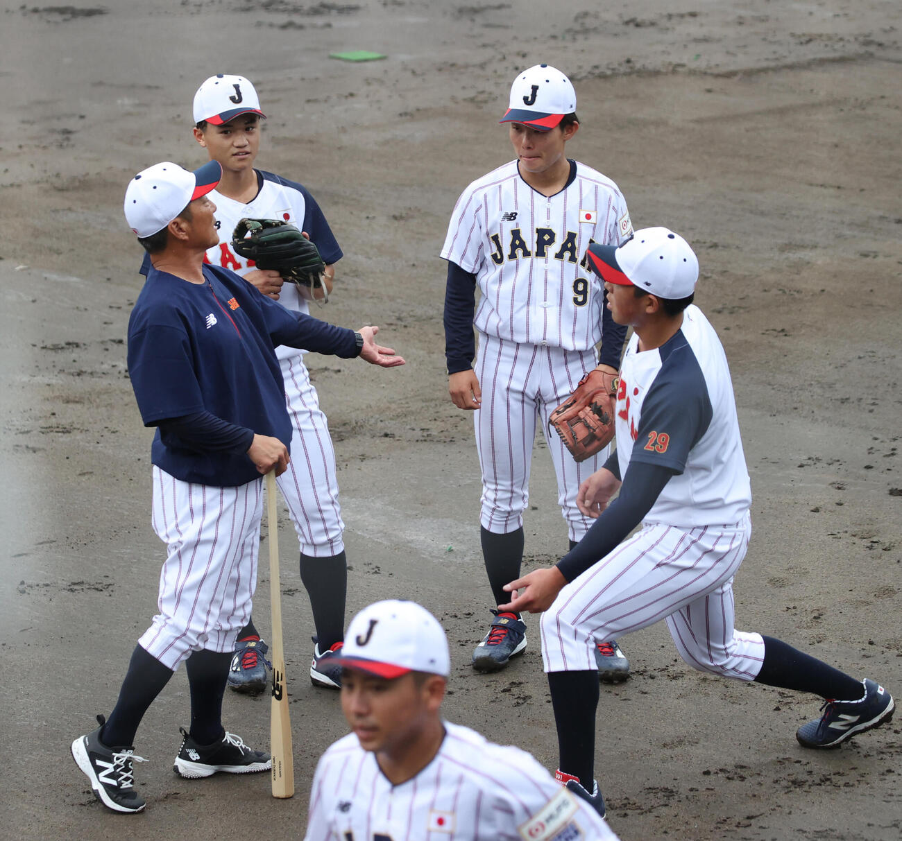大島公一コーチ（左）は法大・井上和輝（右端）、慶大・林純司（中央左）、中京大・鈴木湧陽にアドバイスする（撮影・柴田隆二）