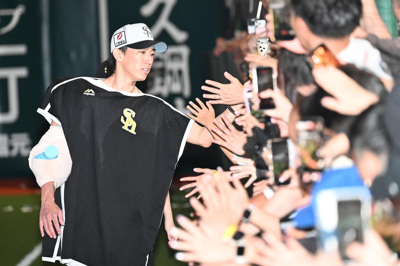 ソフトバンク対西武　ファンとタッチを交わす大津亮介（撮影・林敢治）