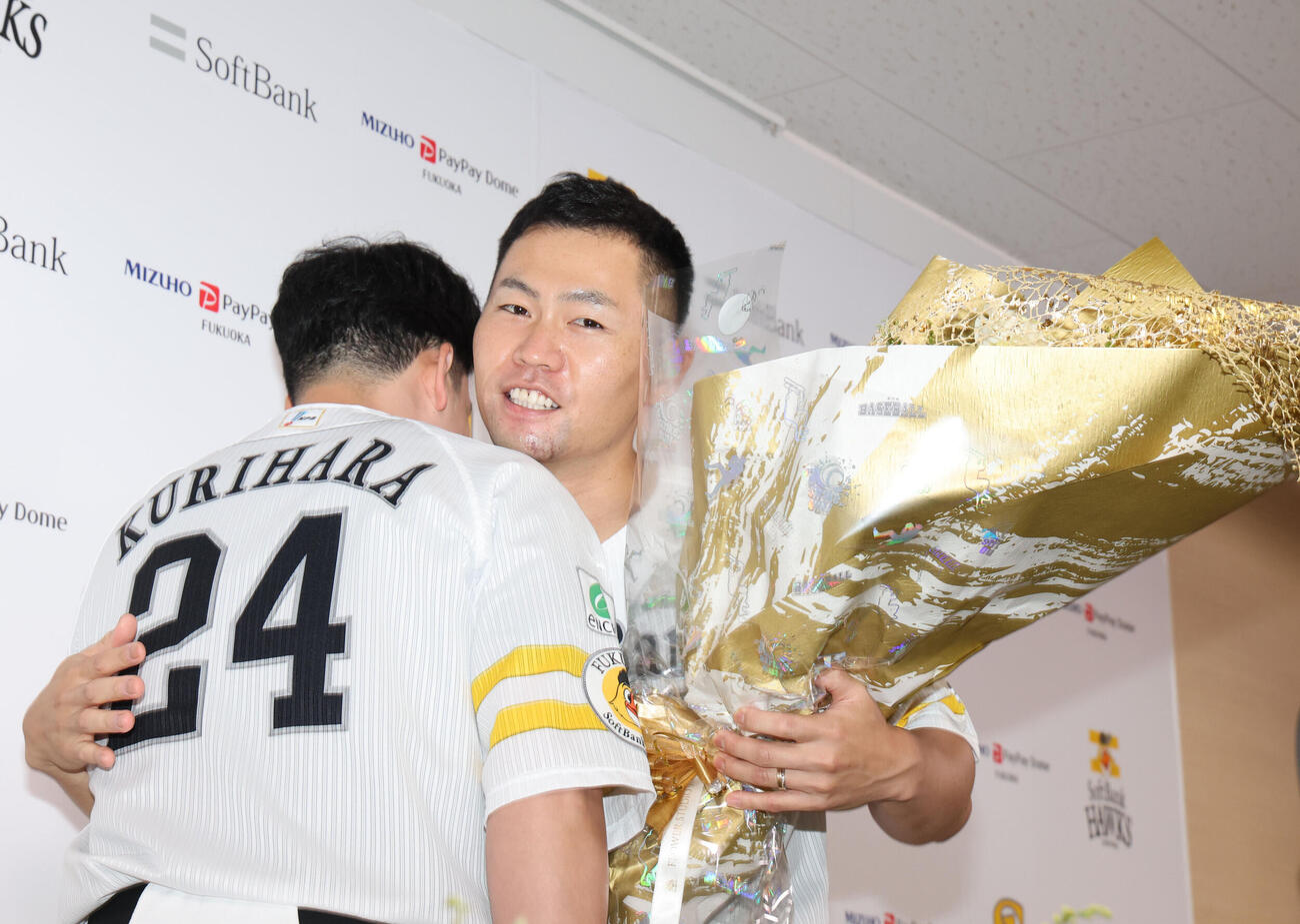引退会見を終えたソフトバンク中村晃は栗原陵矢から花束を贈られる（撮影・梅根麻紀）