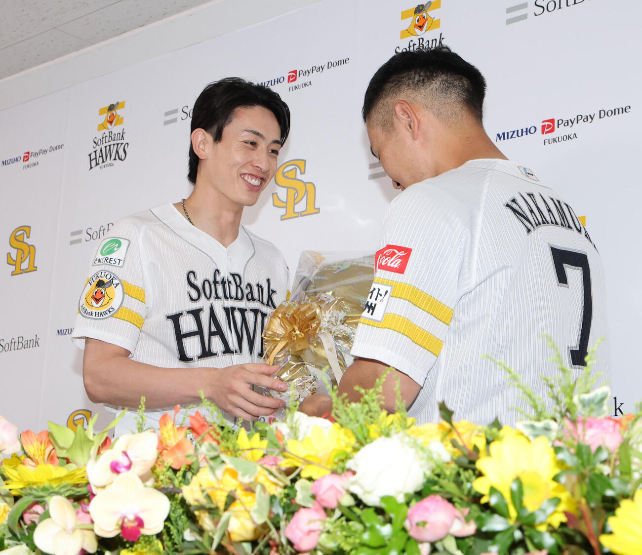 引退会見を終えたソフトバンク中村晃は周東佑京から花束を贈られる（撮影・梅根麻紀）