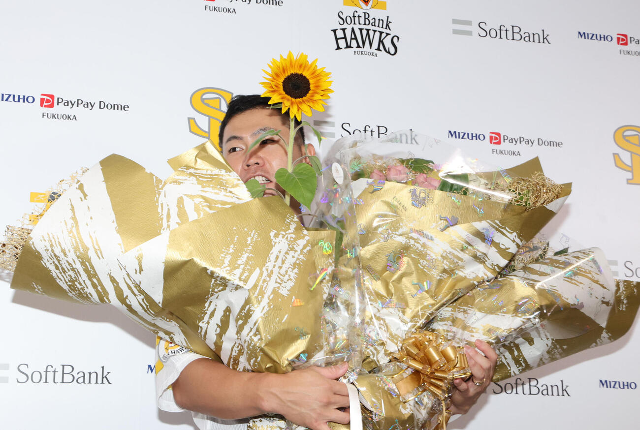 引退会見を終えたソフトバンク中村晃は花束で埋もれる（撮影・梅根麻紀）