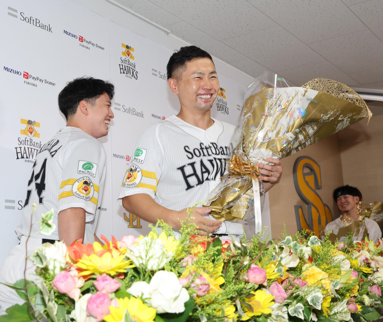 引退会見を終えたソフトバンク中村晃は栗原陵矢から花束を贈られる（撮影・梅根麻紀）