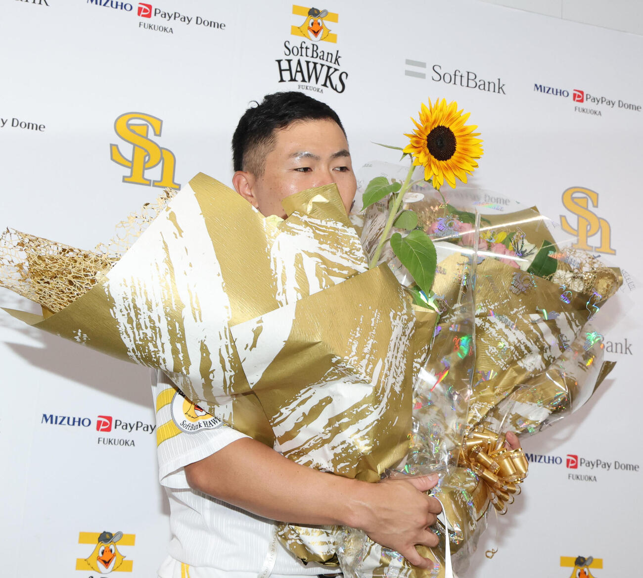 引退会見を終えたソフトバンク中村晃は花束で埋もれる（撮影・梅根麻紀）