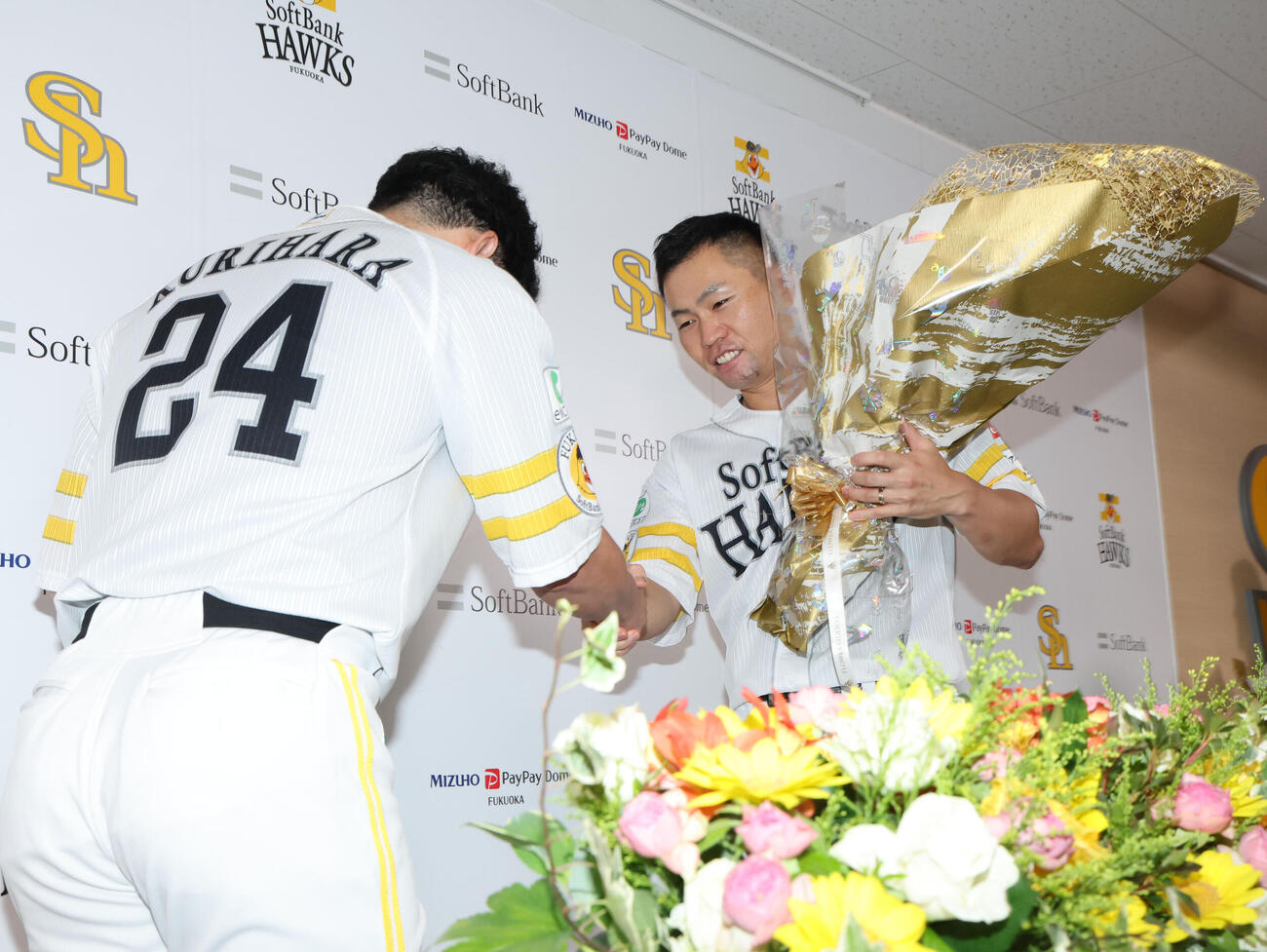 引退会見を終えたソフトバンク中村晃は栗原陵矢から花束を贈られる（撮影・梅根麻紀）
