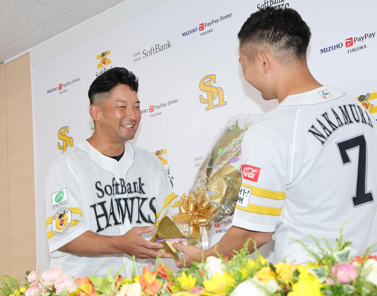 引退会見を終えた嶺井博希から花束を贈られるソフトバンク中村晃（撮影・梅根麻紀）