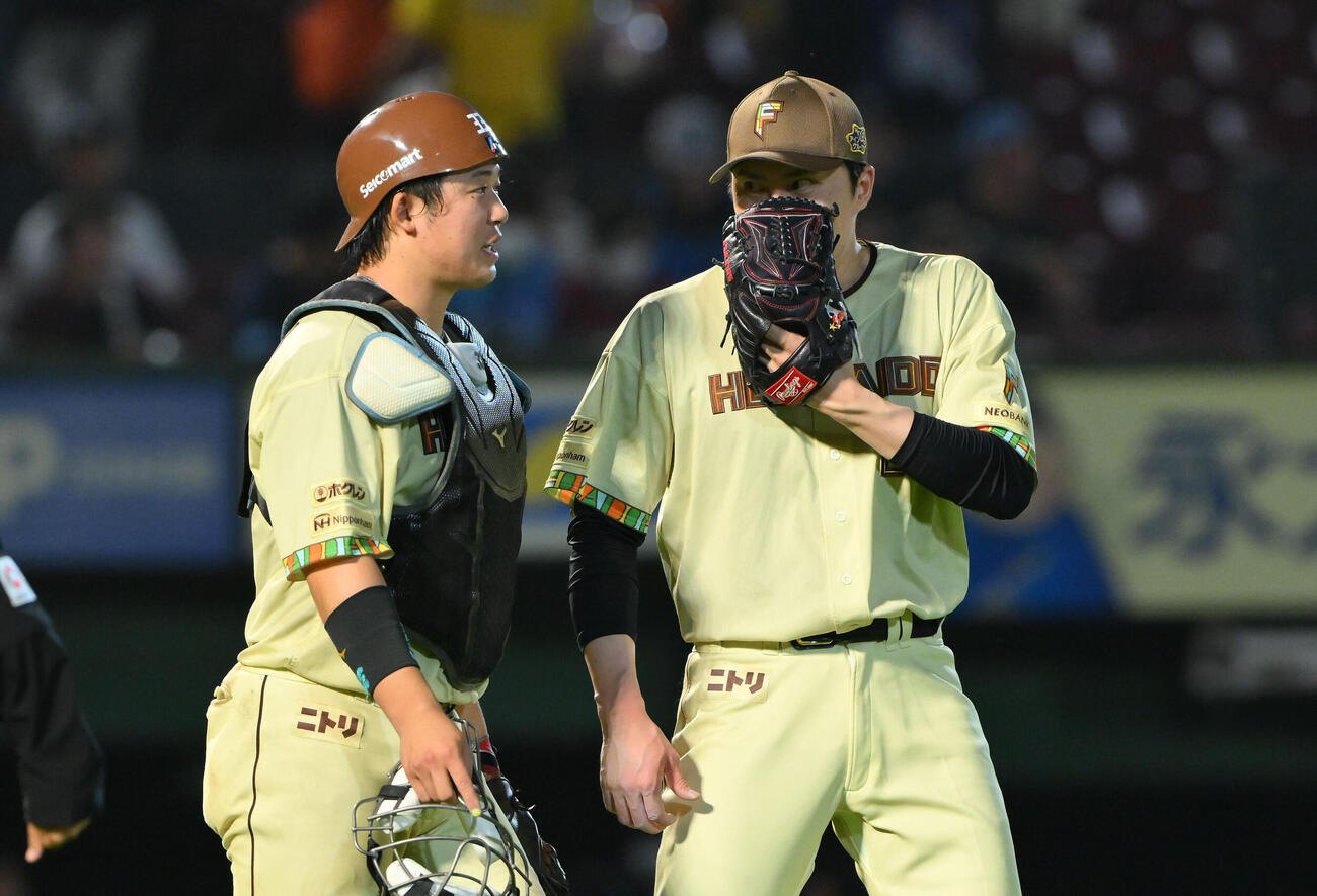 楽天対日本ハム　日本ハム6番手で登板し試合を締めた田中正義（右）は進藤勇也と話す（撮影・滝沢徹郎）