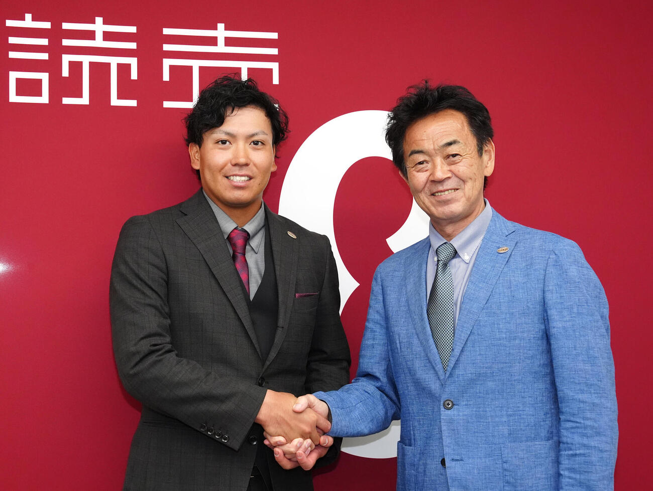 支配下登録選手となり、会見後、巨人水野雄仁編成本部長スカウト・国際担当（右）と握手を交わす知念大成（撮影・江口和貴）