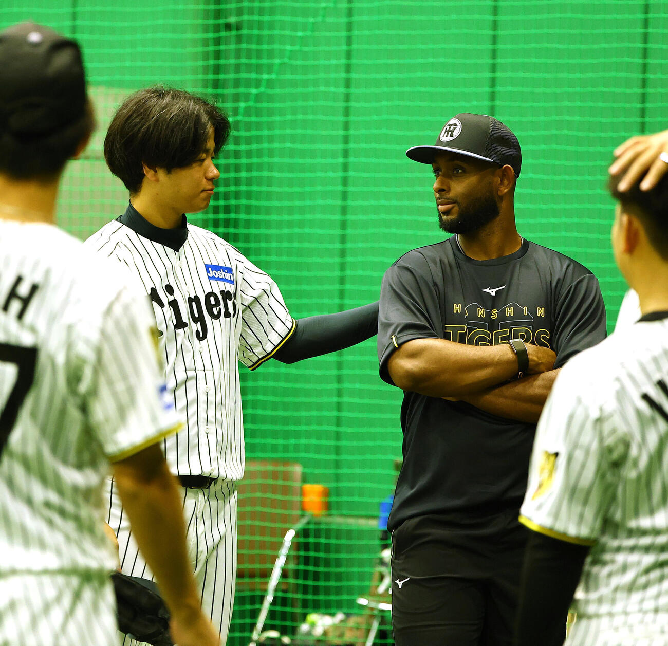 阪神新外国人のアンダーソン・セベリーノ（右）は高橋遥人と話をする（撮影・上田博志）