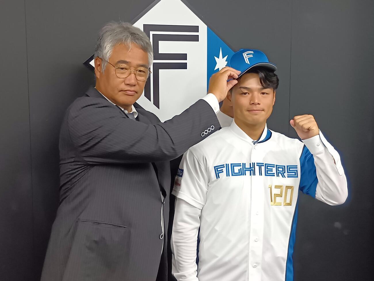入団会見に臨んだ日本ハムの日渡騰輝捕手。左は日本ハムの木田GM代行（撮影・撮影・沢田啓太郎）