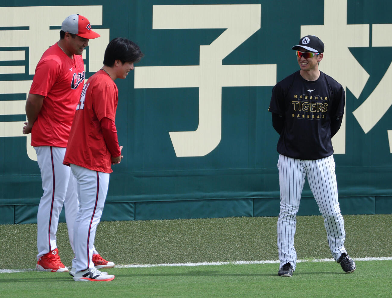 練習中、阪神近本光司は広島黒原拓未、末包昇大と談笑する（撮影・西尾就之）
