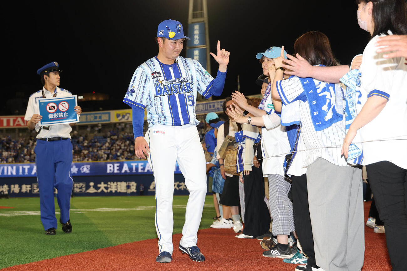 DeNA対中日　中日に勝利し、ファンとタッチを交わす石田裕太郎（撮影・河田真司）