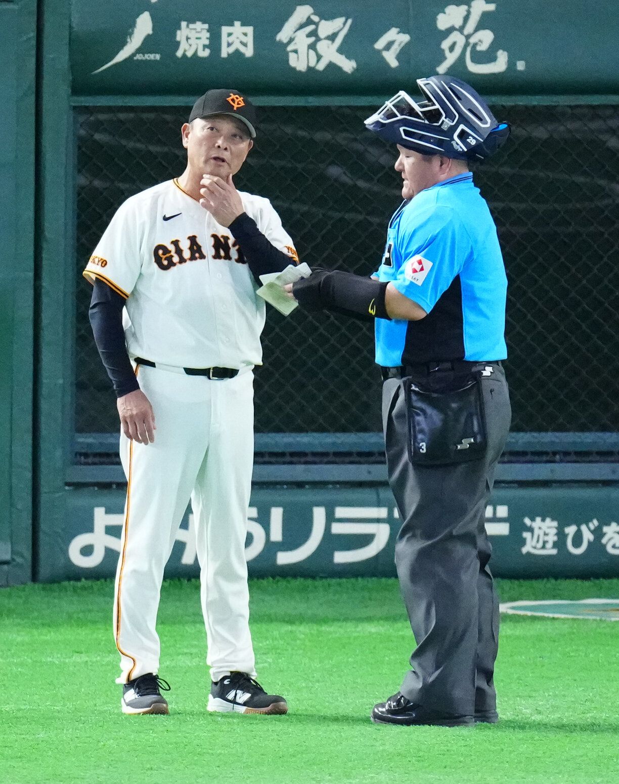 巨人対阪神　8回表開始前、敷田直人球審（右）に選手交代を告げる巨人橋上秀樹監督代行（撮影・江口和貴）