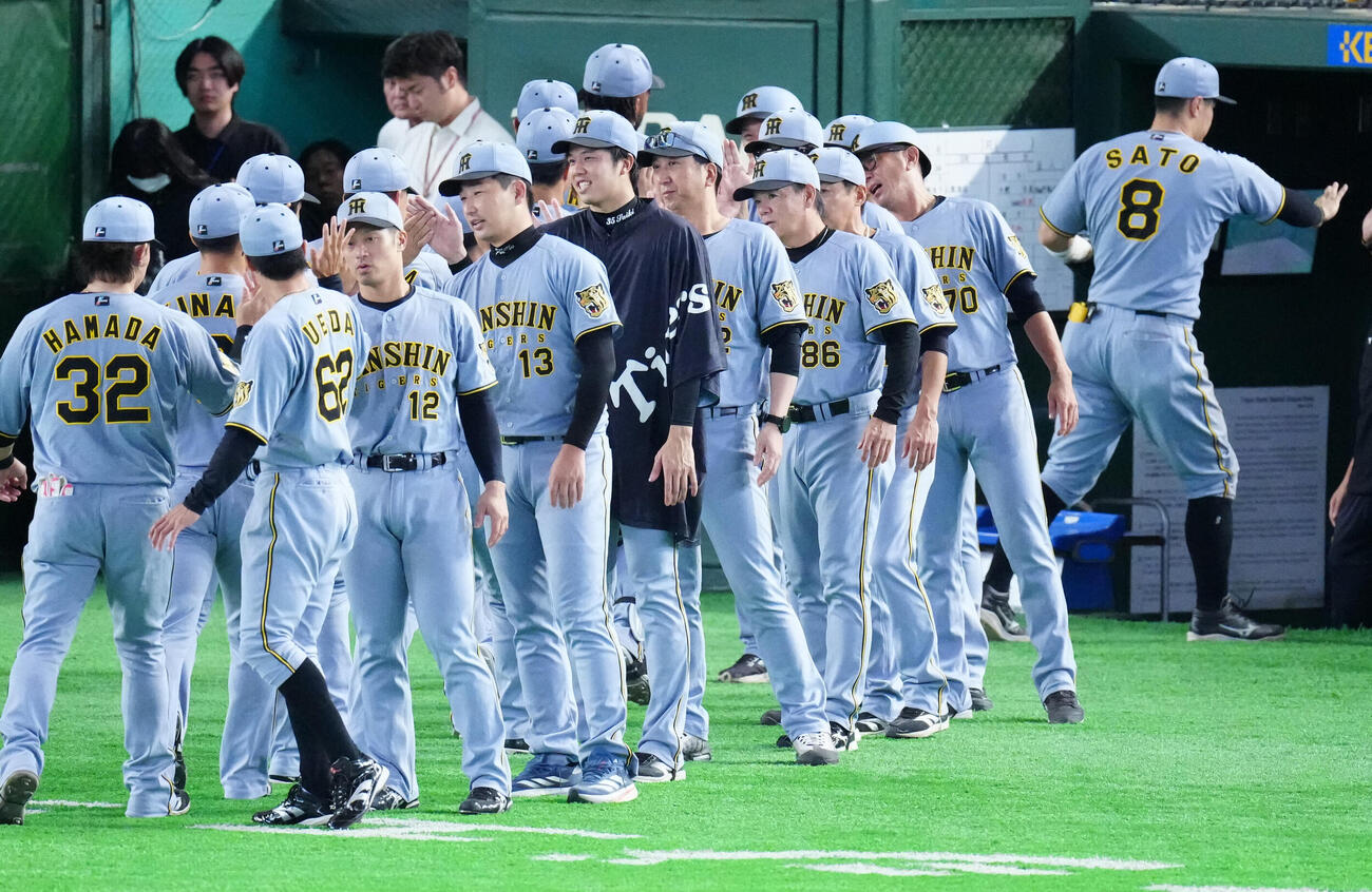 巨人対阪神　試合後、勝利のタッチを交わす阪神藤川球児監督（中央右）と才木浩人（同左）ら（撮影・江口和貴）