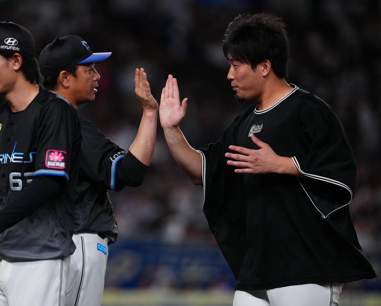 ロッテ対オリックス　オリックスに勝利し、サブロー監督（左）とタッチを交わすロッテ八木彬（撮影・鈴木みどり）
