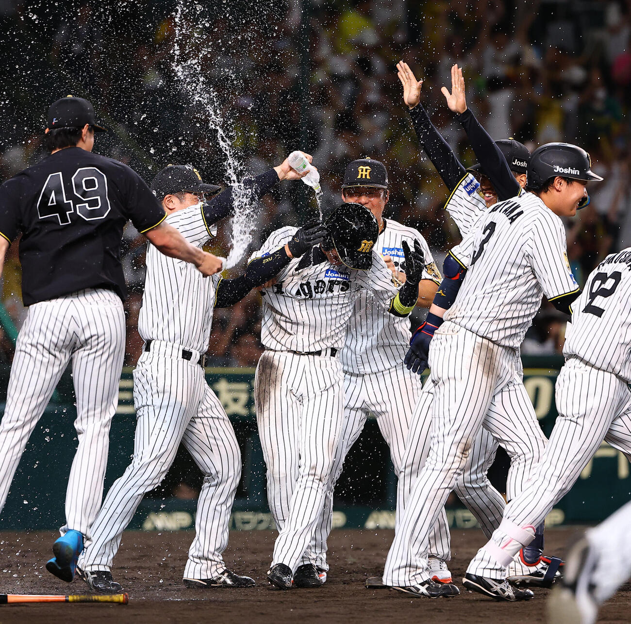 阪神対ヤクルト　9回裏阪神1死一、二塁、サヨナラの生還を果たした近本光司（中央）はウオーターシャワーを浴びる（撮影・上田博志）