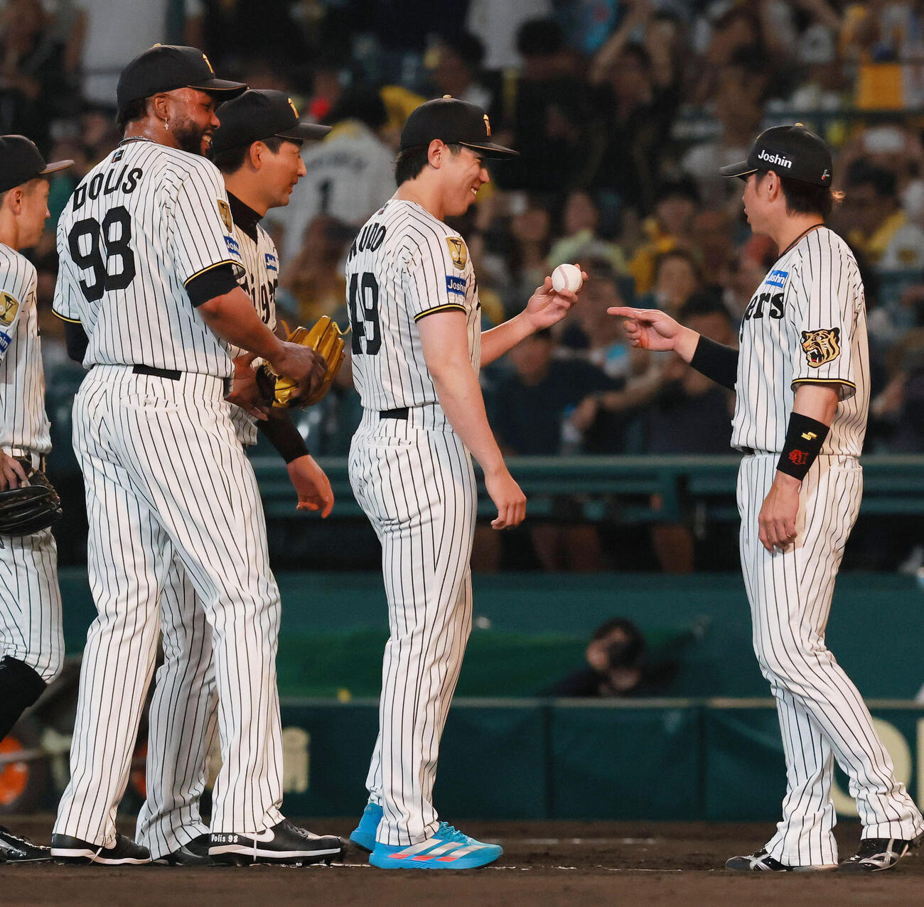 阪神対ヤクルト　初勝利を挙げた阪神工藤泰成（右から2人目）はラファエル・ドリスからウイニングボールを受け取り笑顔を見せる（撮影・上山淳一）