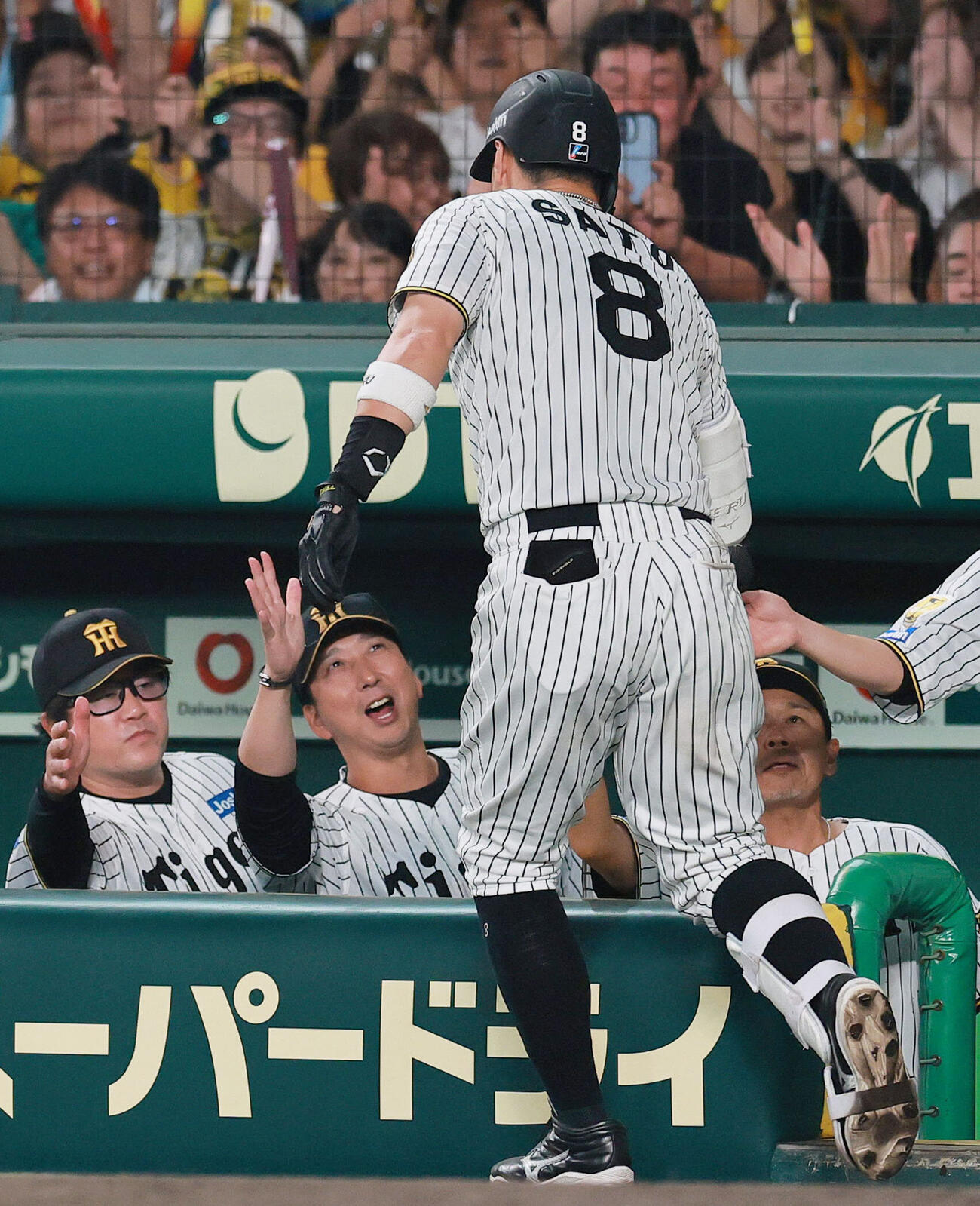 阪神対ヤクルト　7回裏阪神1死一塁、2点本塁打を放った佐藤輝明（手前）を出迎える藤川球児監督（左から2人目）（撮影・上山淳一）