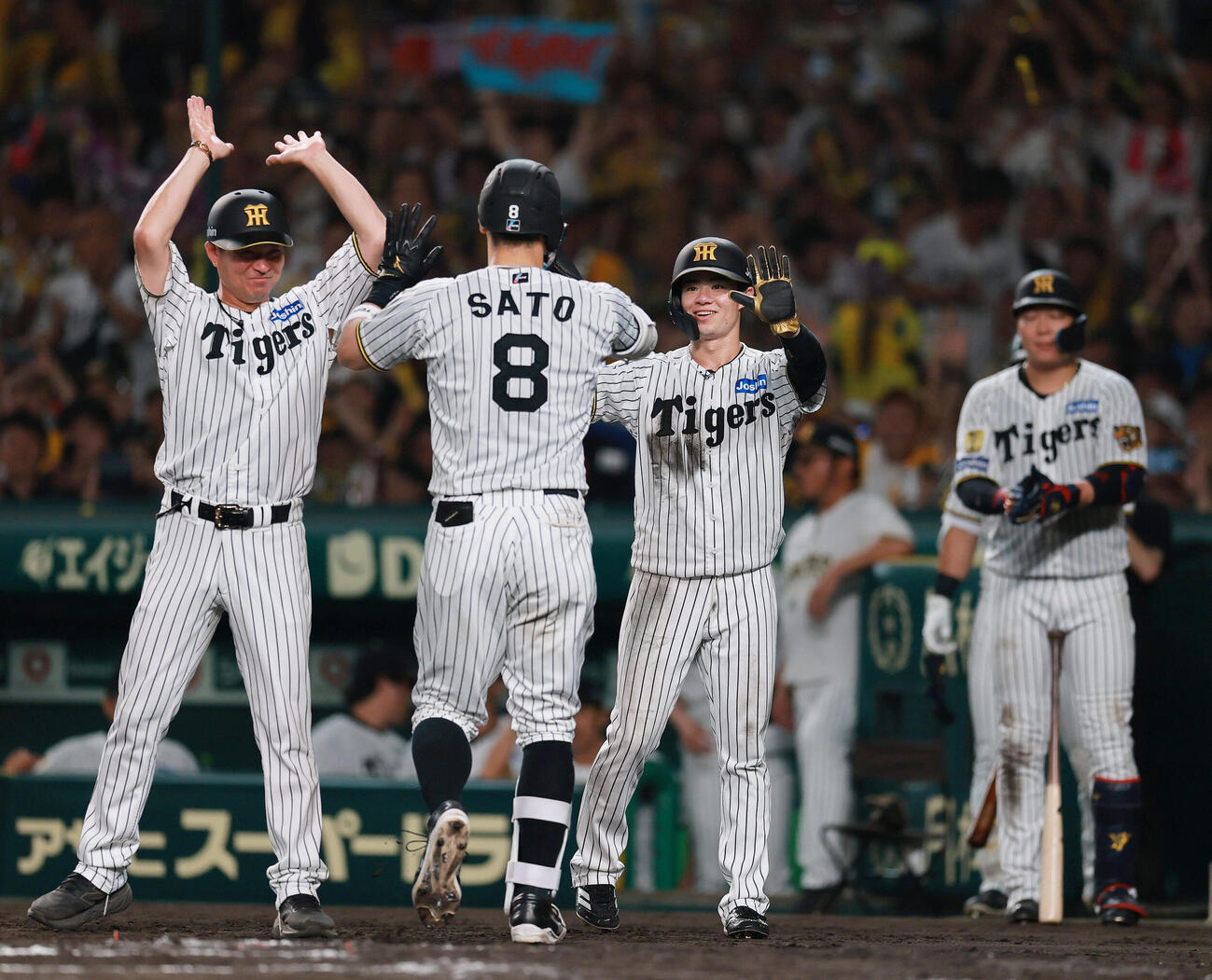 阪神対ヤクルト　7回裏阪神1死一塁、佐藤輝明（手前）は2点本塁打を放ち生還する（撮影・上山淳一）