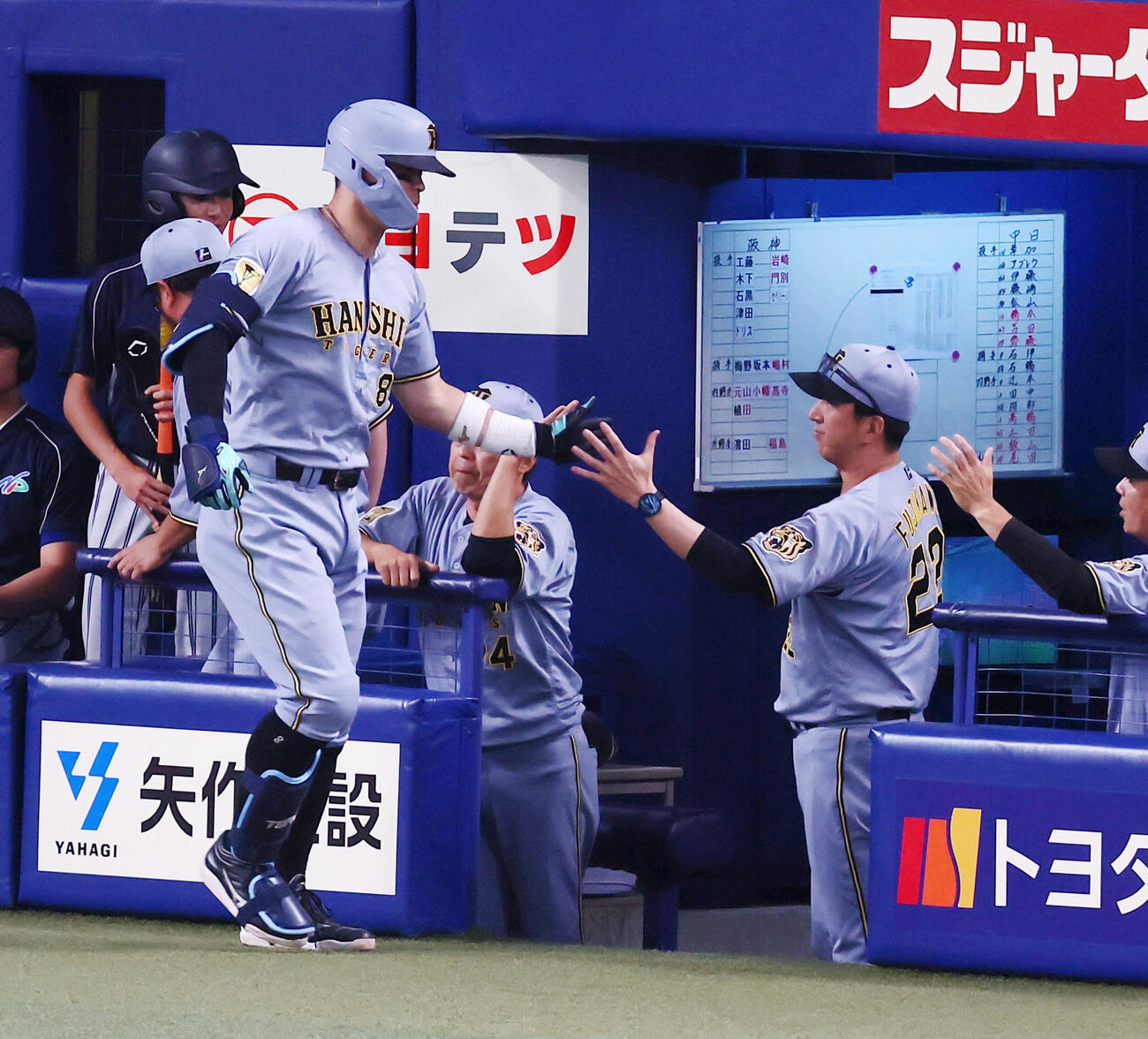 中日対阪神　1回表阪神2死、佐藤輝明は右越えソロ本塁打を放ちベンチの藤川球児監督（右）とタッチする（撮影・加藤哉）