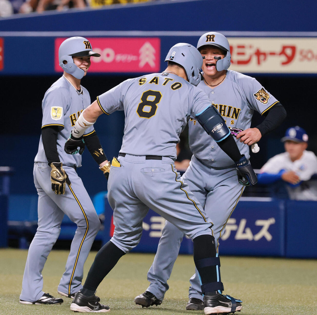 中日対阪神　8回表阪神1死一、二塁、佐藤輝明（手前）は3点本塁打を放ち生還しポーズする。右は一走森下翔太、左は二走中野拓夢（撮影・上山淳一）