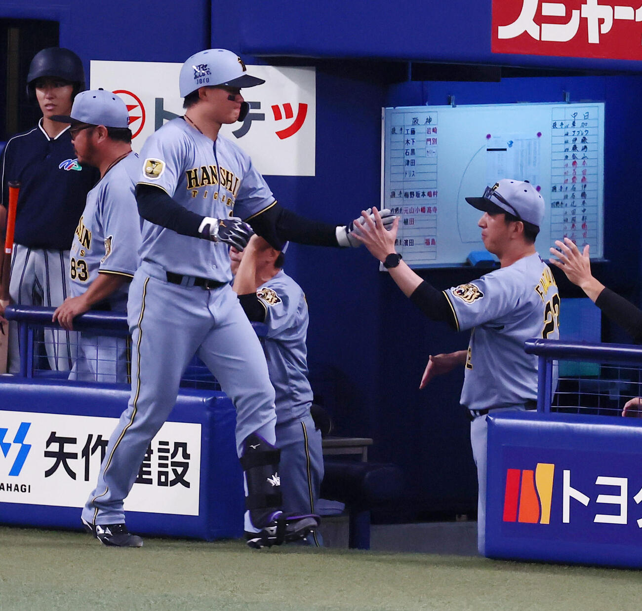 中日対阪神　1回表阪神2死、森下翔太は先制ソロ本塁打を放ちベンチの藤川球児監督（右）とタッチする（撮影・加藤哉）