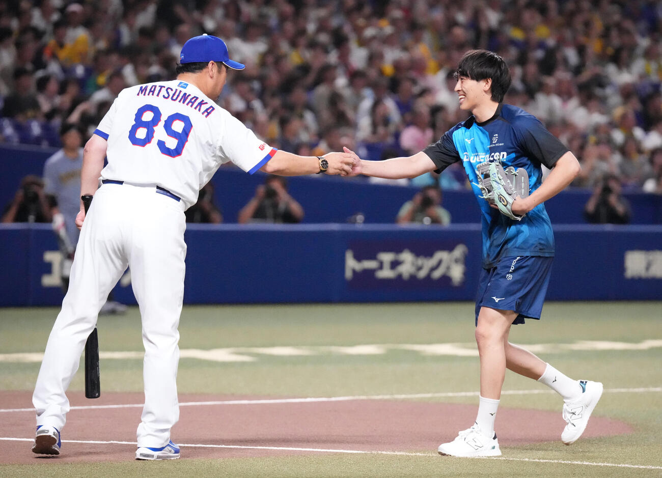 中日対阪神　試合前、始球式を行ったハンドボール選手の松中大輝（右）は打席に入った父の松中信彦打撃統括コーチと握手を交わす（撮影・森本幸一）