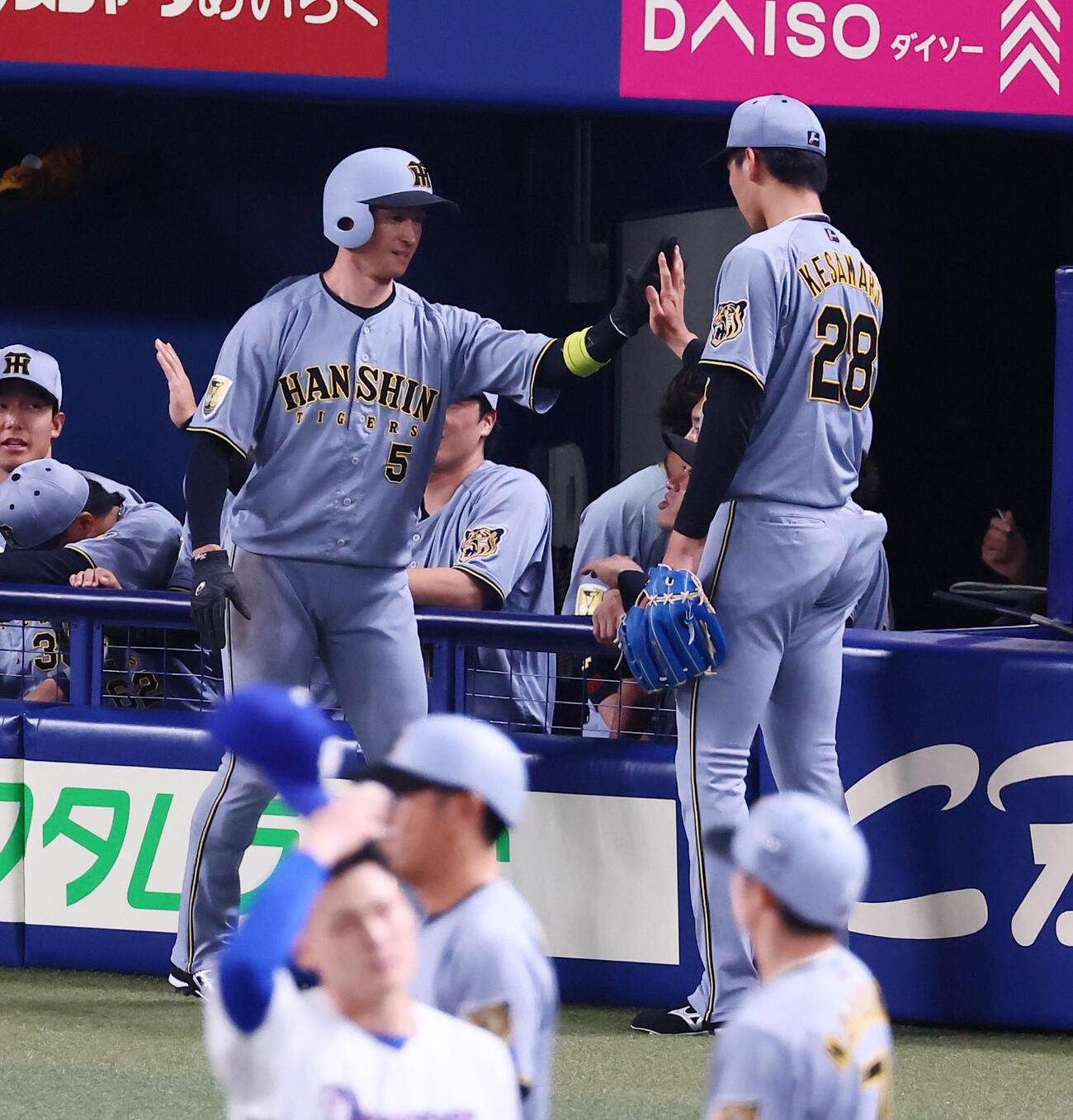 中日対阪神　1回表阪神無死一、三塁、森下翔太の適時二塁打で生還した近本光司はベンチ前の今朝丸裕喜（右）とタッチ（撮影・加藤哉）