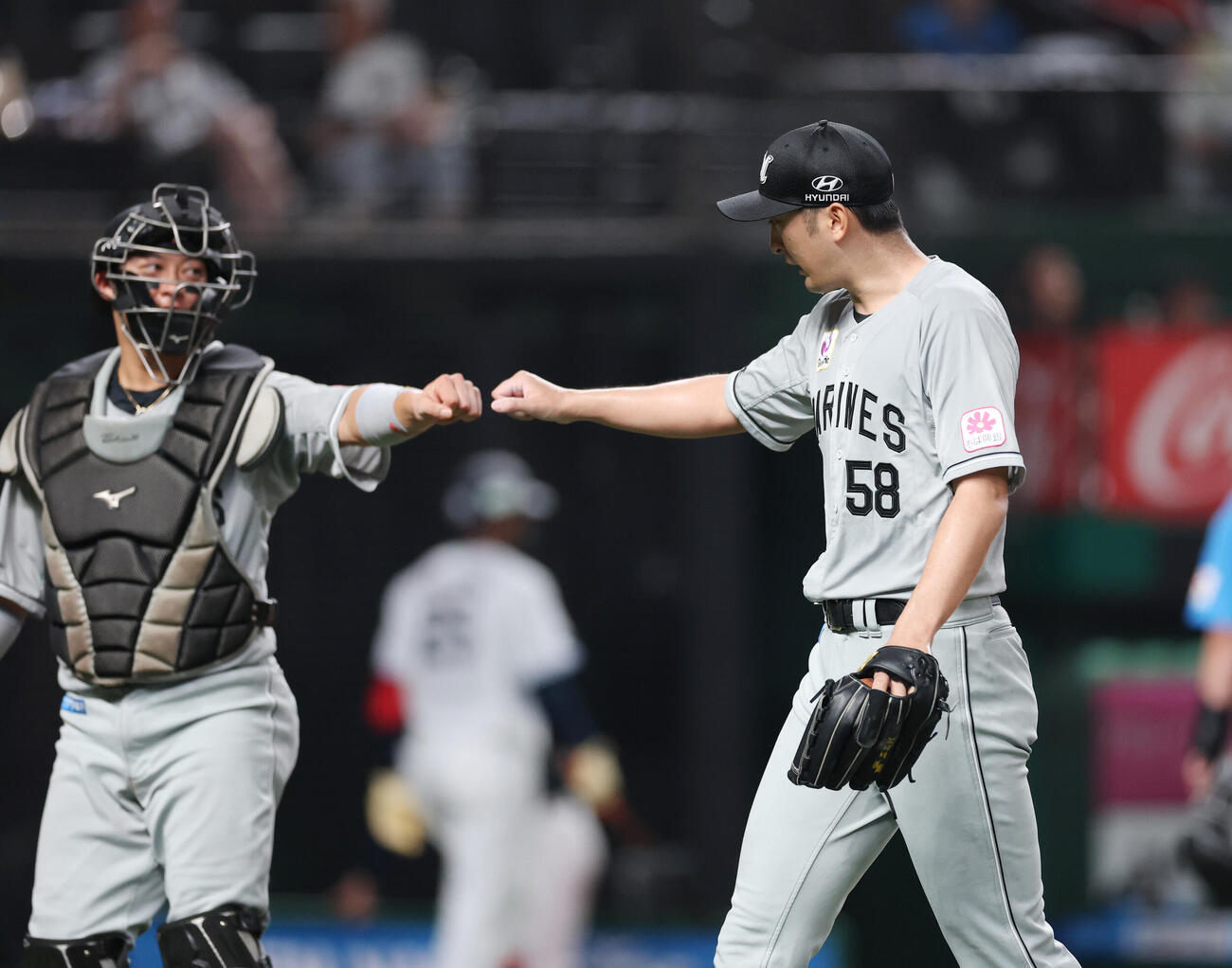 西武対ロッテ　5回裏を終え、タッチを交わす佐藤都志也（左）と河村説人（撮影・増田悦実）
