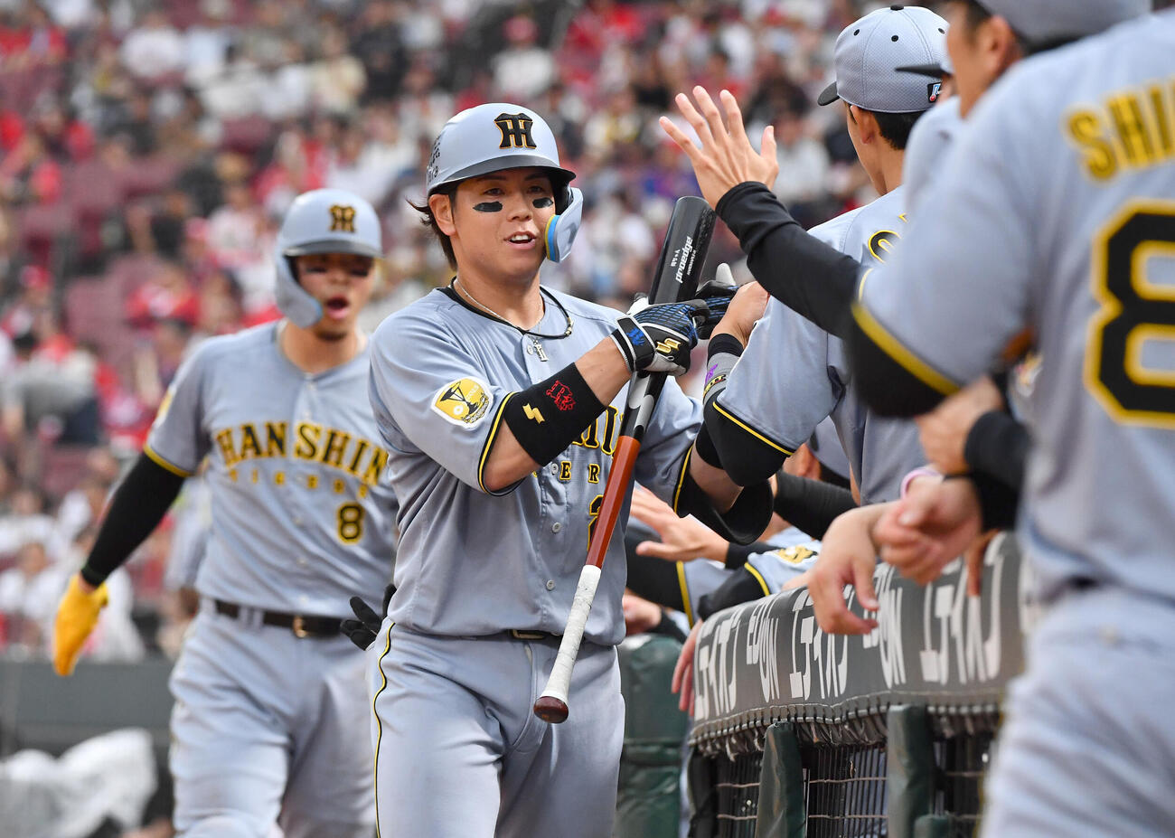 広島対阪神　4回表阪神無死満塁、先制の中犠飛を放ち、ナインとタッチを交わす梅野隆太郎（撮影・岩下翔太）