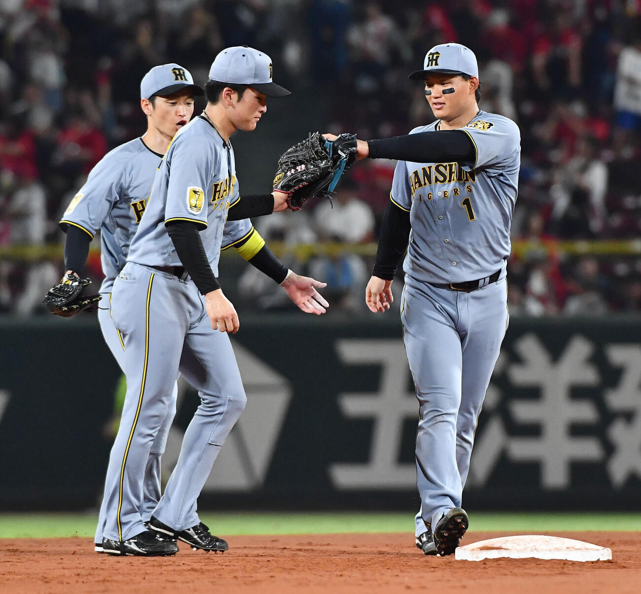 広島対阪神　広島に勝利しタッチを交わす阪神の、左から近本光司、高寺望夢、森下翔太（撮影・岩下翔太）
