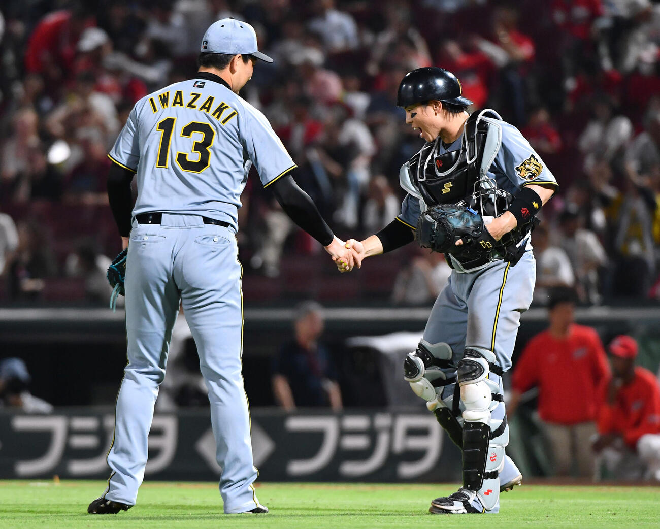 広島対阪神　広島に勝利し、最終回を締めた岩崎優（左）と握手を交わす梅野隆太郎（撮影・岩下翔太）