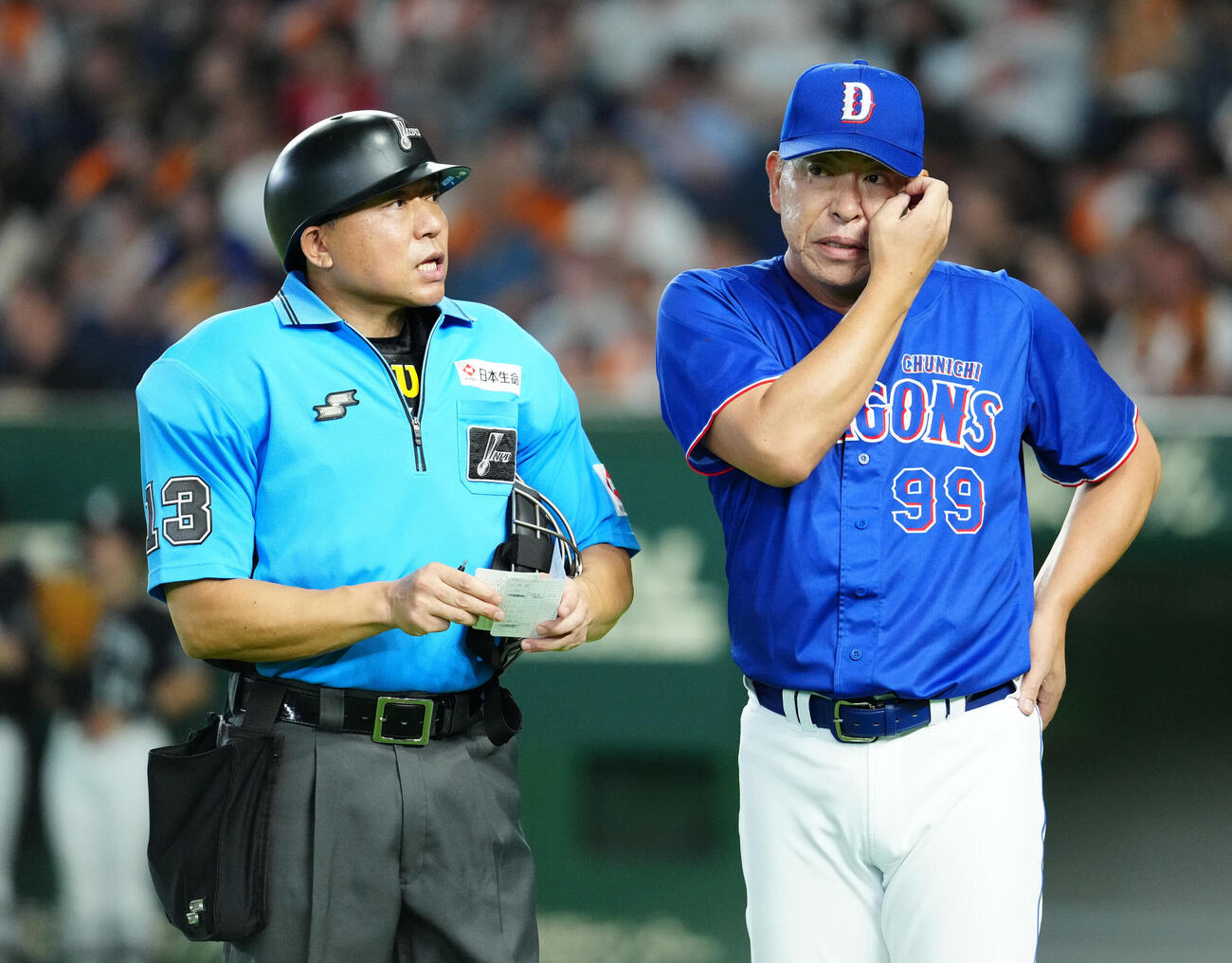 巨人対中日　9回表中日2死、石伊雄太が死球を受け、治療中に山口義治球審（左）と話す井上一樹監督（撮影・江口和貴）