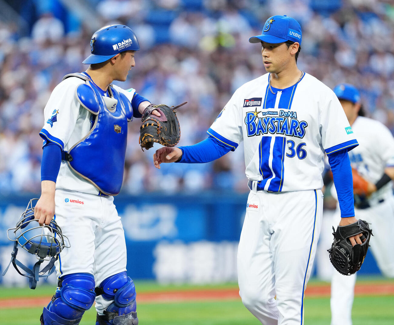 DeNA対ヤクルト　1回表を終え、松尾汐恩（左）とタッチを交わすDeNA尾形崇斗（撮影・鈴木みどり）