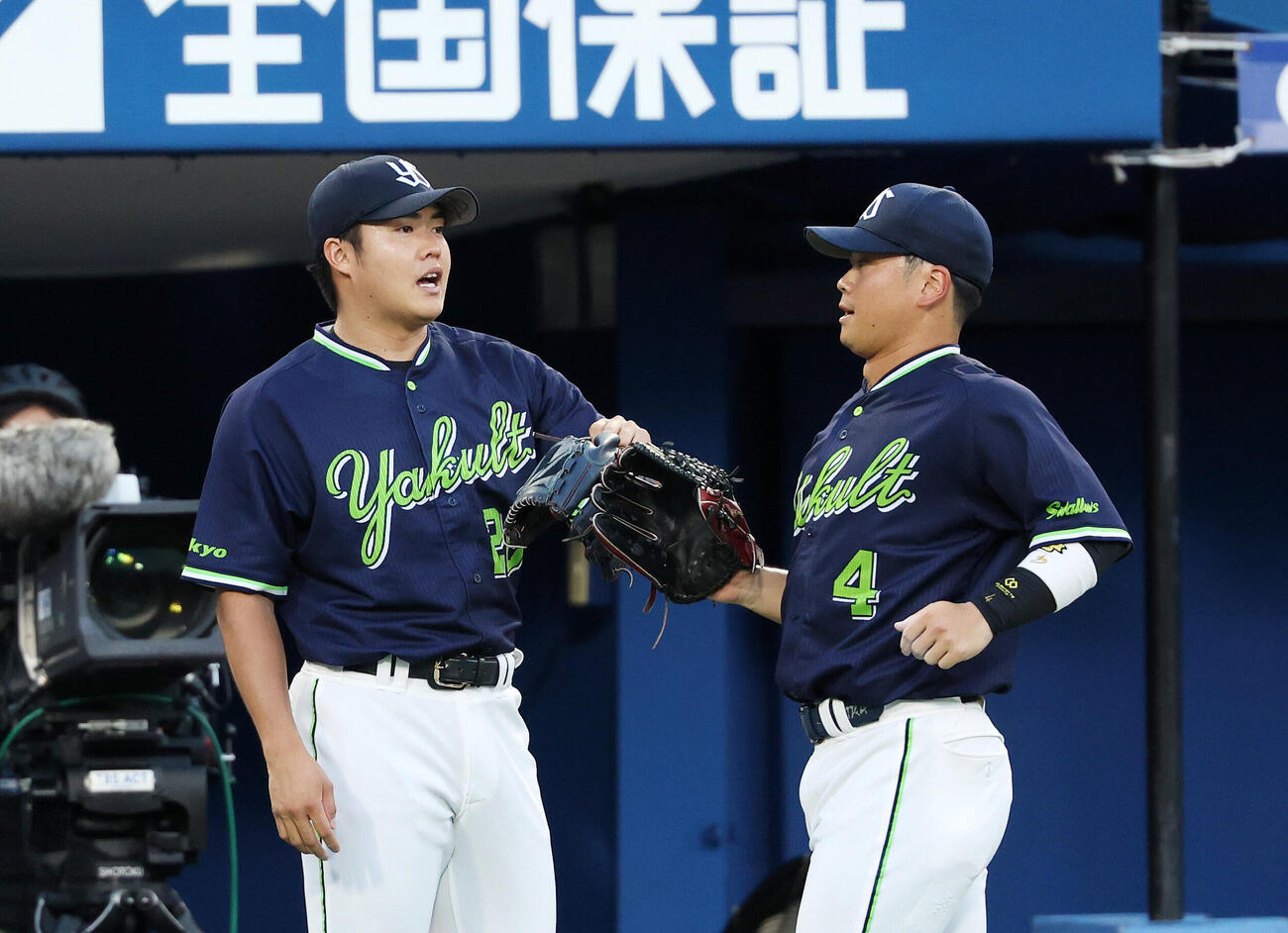 DeNA対ヤクルト　2回裏、DeNAの攻撃を抑えベンチ前でヤクルト丸山和郁（右）を迎える松本健吾（撮影・鈴木正人）