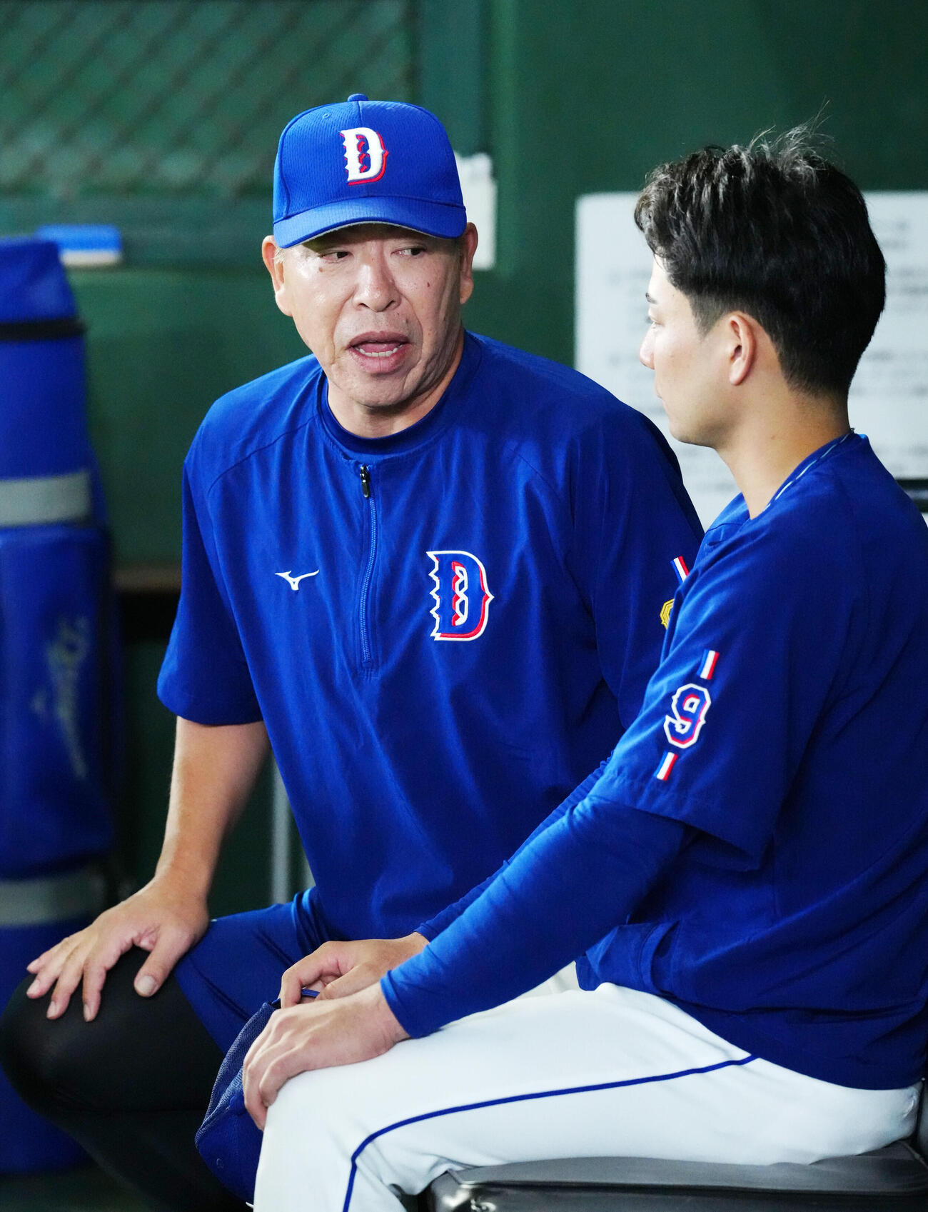 巨人対中日　試合前練習中、ベンチで中日石伊雄太（右）と話す井上一樹監督（撮影・江口和貴）