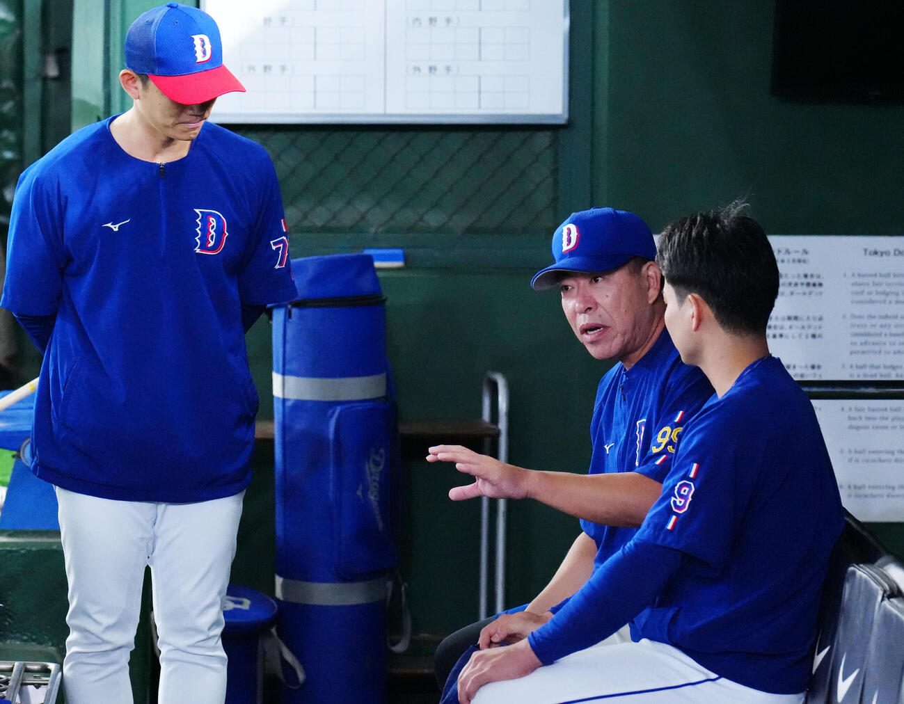 巨人対中日　試合前練習中、ベンチで中日石伊雄太（右）と話す井上一樹監督（撮影・江口和貴）