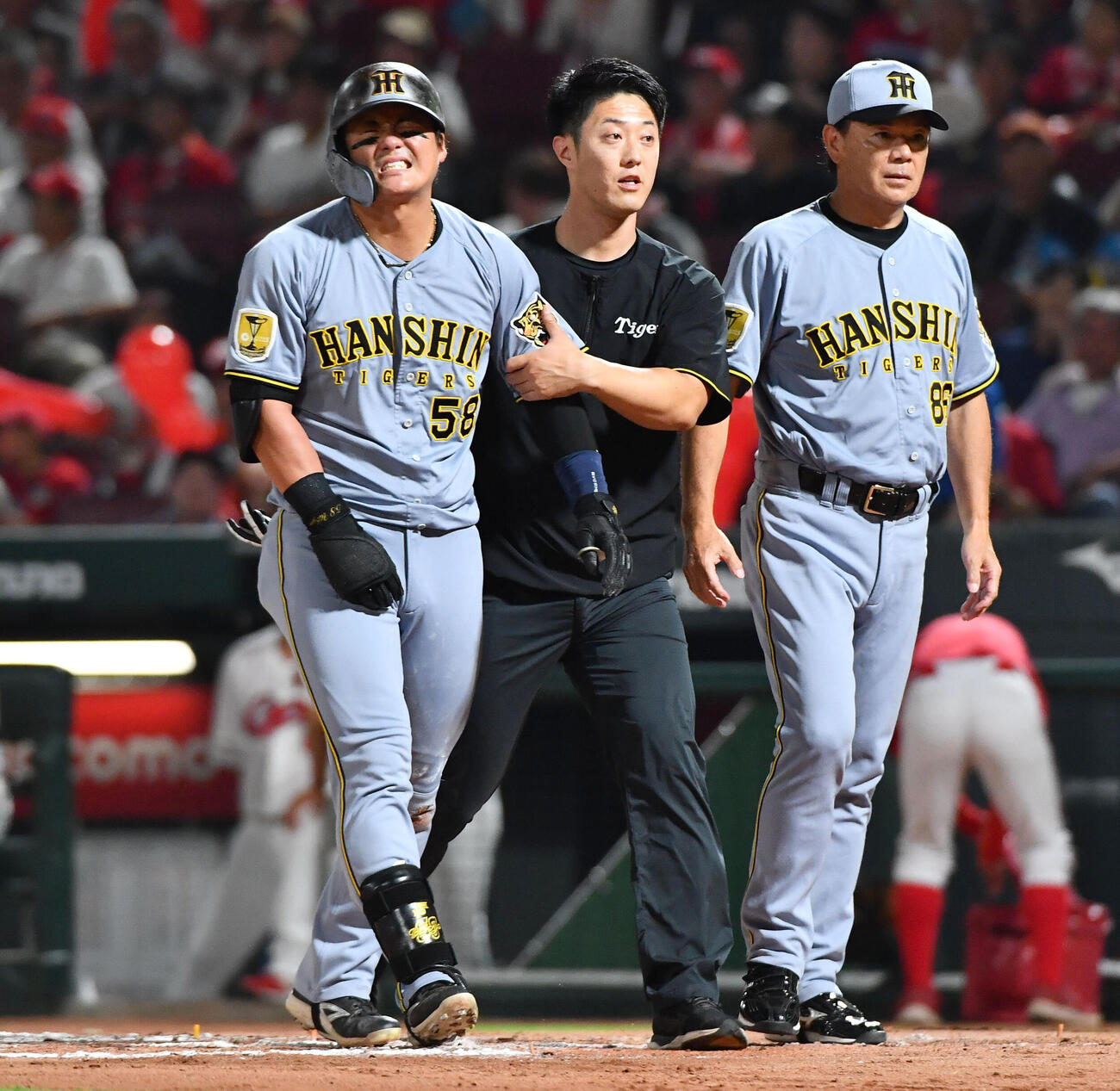 背中に死球を受け、トレーナーとベンチへ戻る前川右京（2026年7月17日撮影）