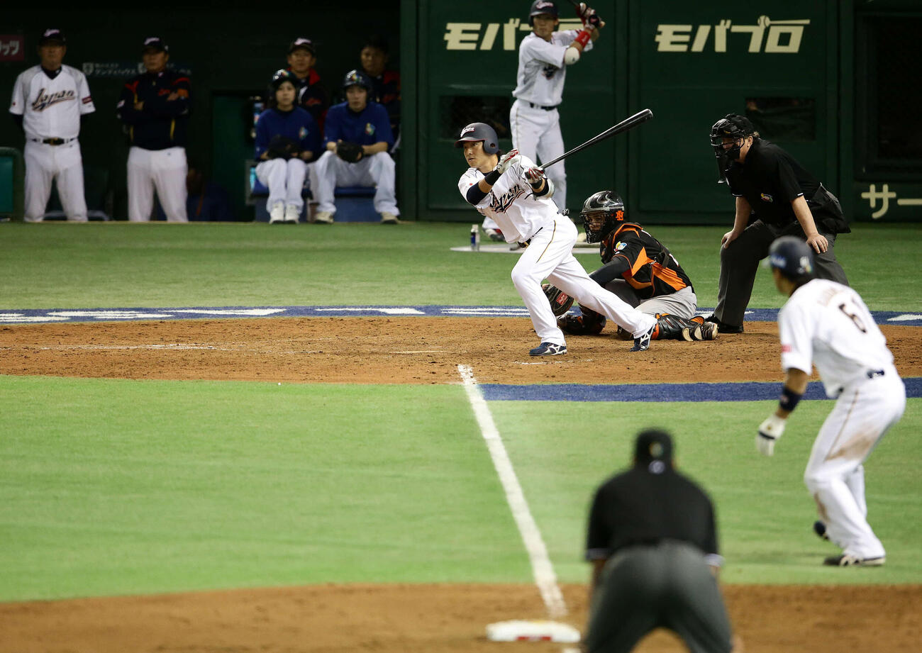 2013年3月、WBC2次ラウンド　オランダ戦の8回裏日本2死二、三塁、左前に2点適時打を放つ長野久義。手前右は三塁走者角中勝也。後方左端は山本浩二監督