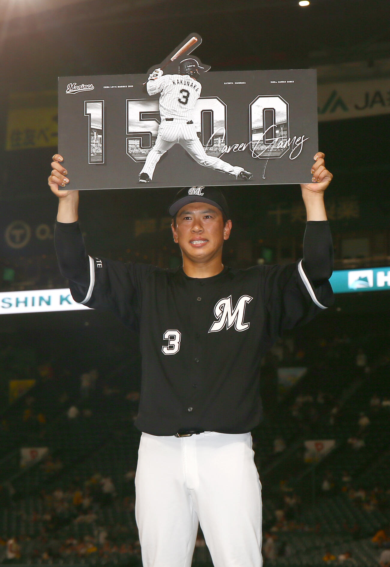 阪神対ロッテ　ロッテ角中勝也は1500試合出場を達成し、記念ボードを掲げる（撮影・上山淳一）＝2025年6月17日、甲子園球場