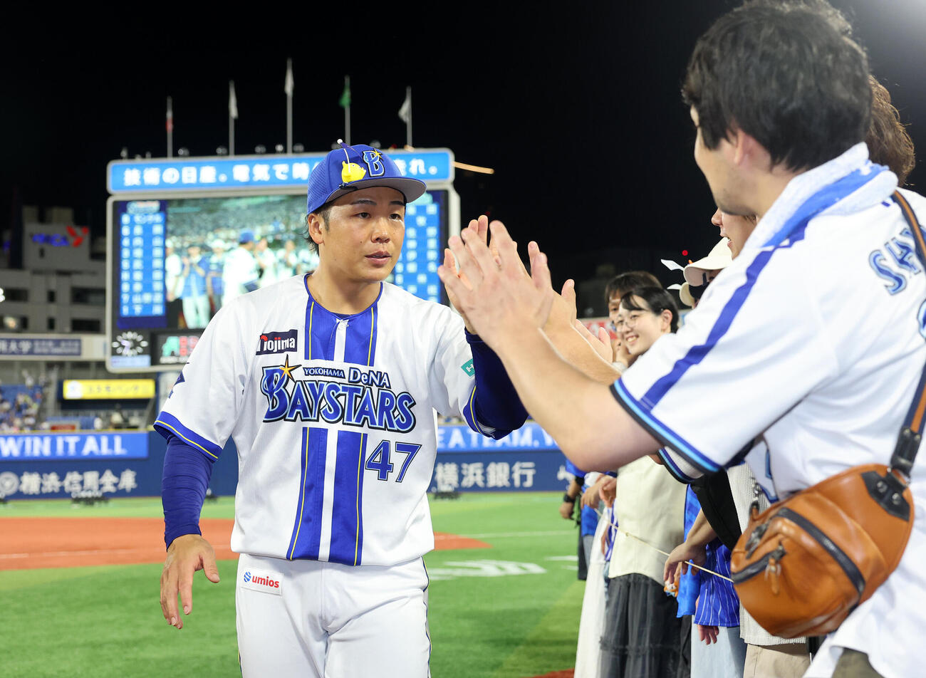 DeNA対ヤクルト　プロ初勝利しファンとタッチするDeNA片山皓心（撮影・鈴木正人）