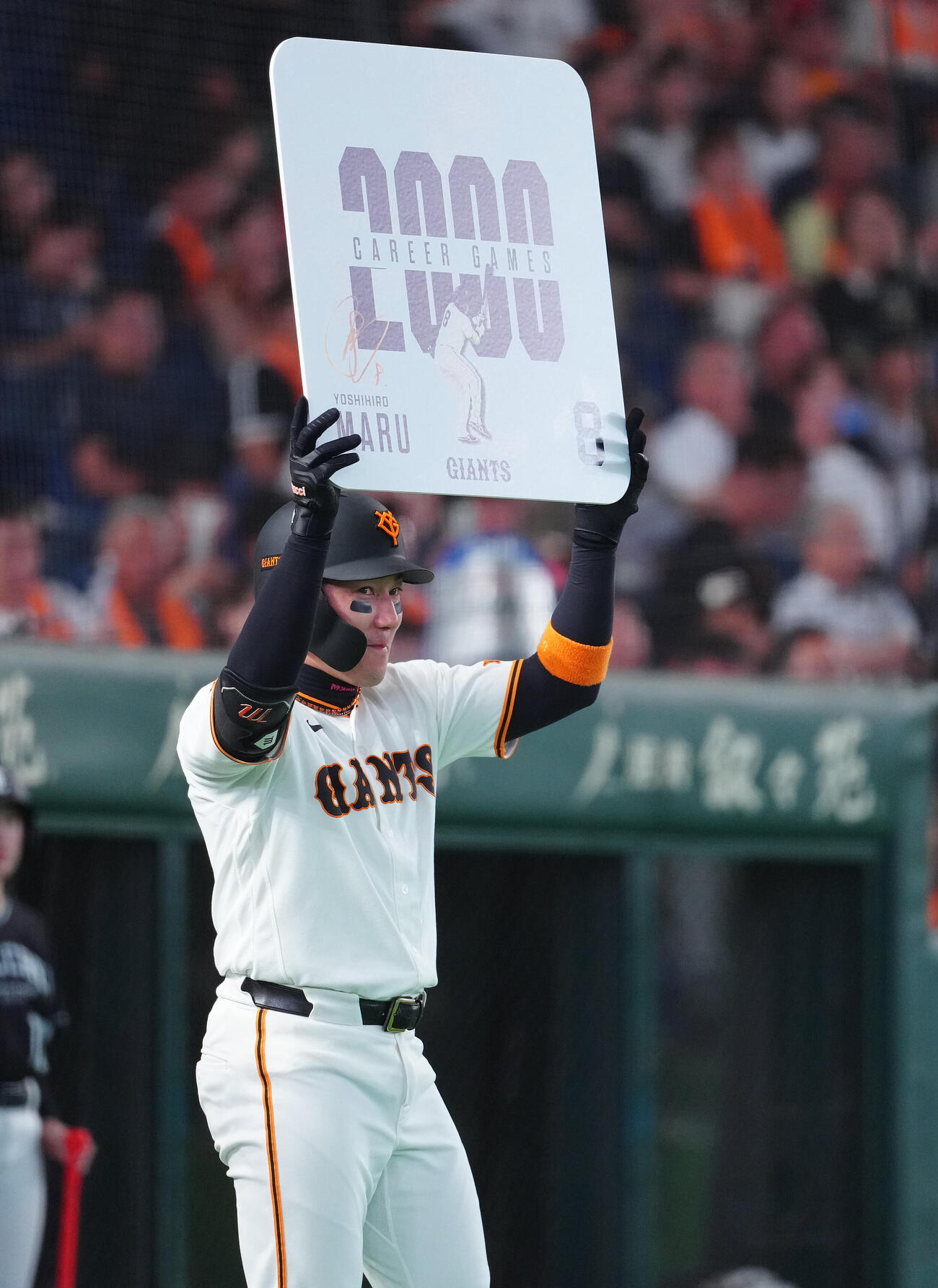 巨人対広島　通算2000試合出場を達成し、ボードを掲げる巨人丸佳浩（撮影・鈴木みどり）