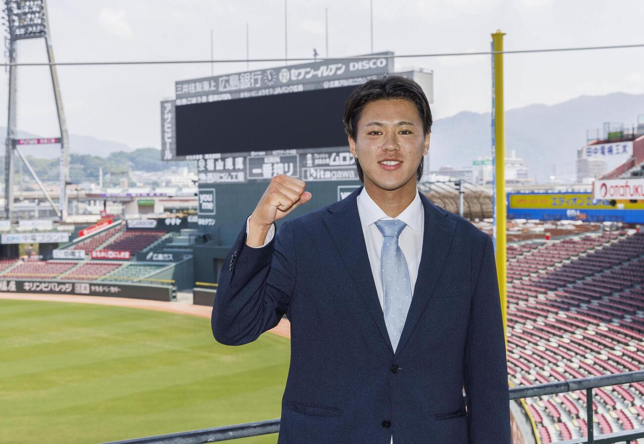 支配下選手契約を結び、ポーズをとる広島・杉田＝21日、マツダスタジアム（球団提供）(共同)