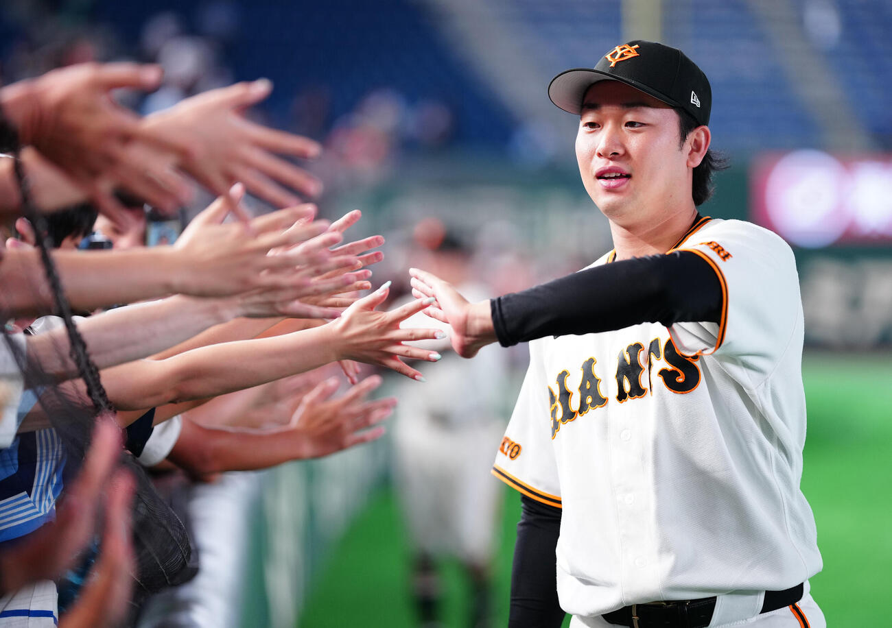 巨人対広島　広島に勝利し、ファンとタッチを交わす巨人山崎伊織（撮影・鈴木みどり）