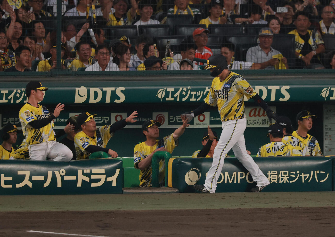 阪神対DeNA 3回裏阪神2死満塁、三走大山悠輔（手前）は伏見寅威の適時打で生還し出迎えを受ける（撮影・上山淳一）