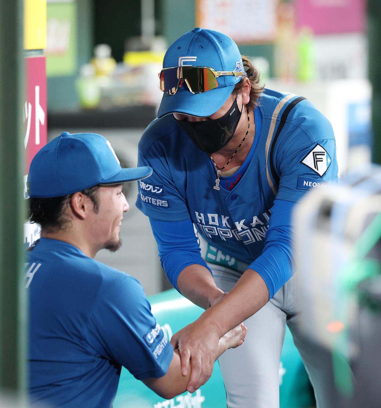 西武対日本ハム　6回裏を終えた日本ハム伊藤大海（左）と握手し右腕に触れる新庄剛志監督（撮影・宮地輝）