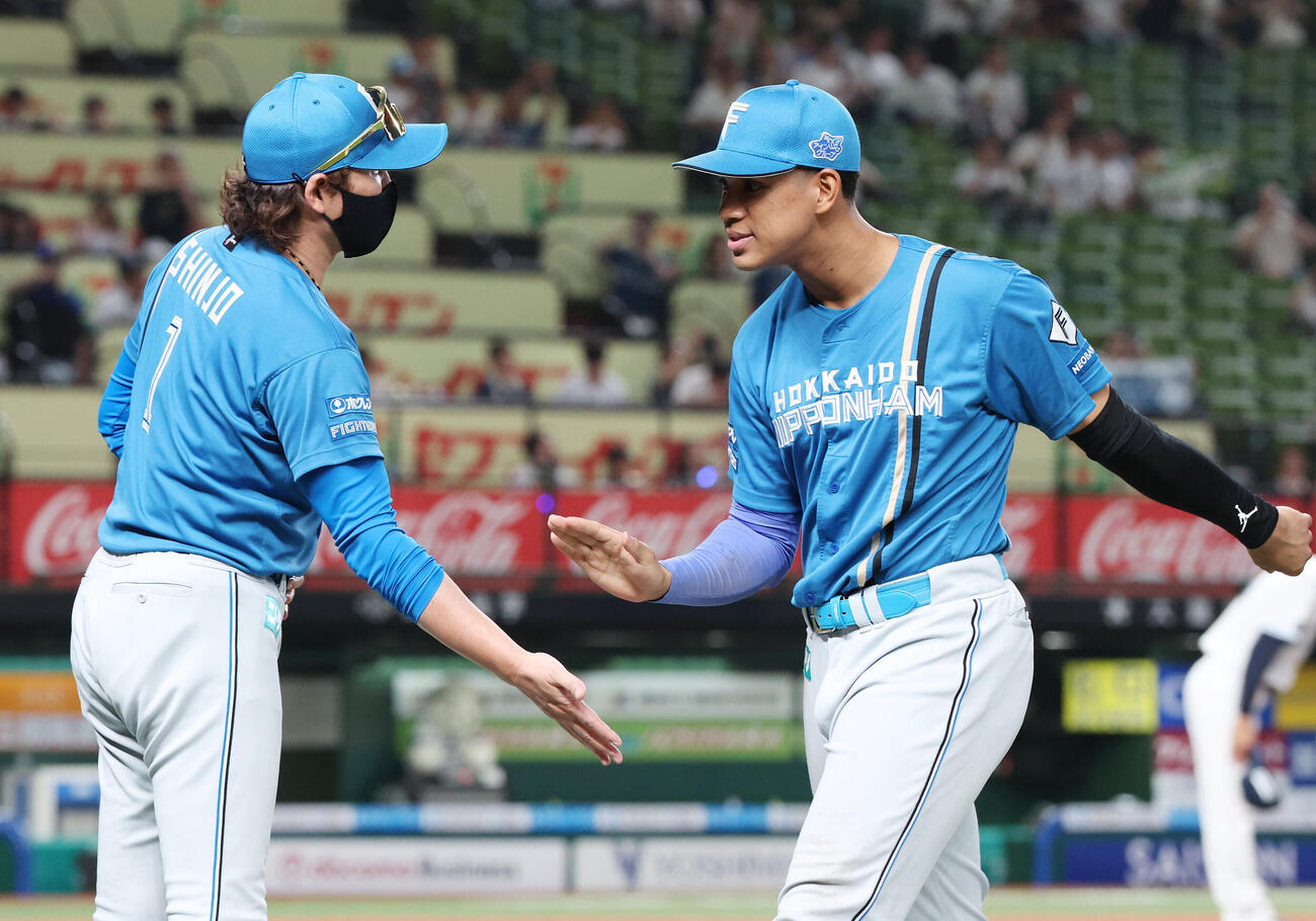 西武対日本ハム　勝利のタッチを交わす日本ハム新庄剛志監督（左）と万波中正（撮影・宮地輝）