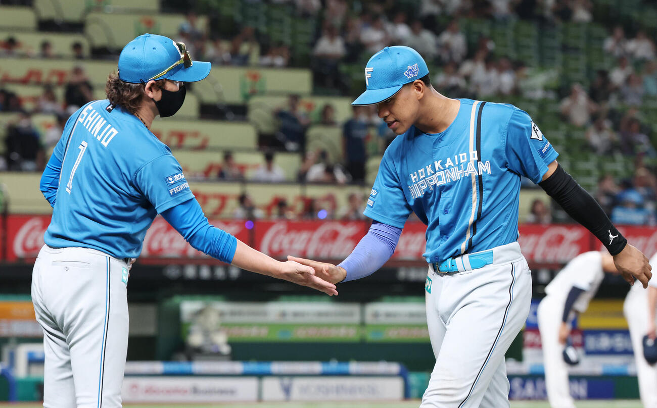 西武対日本ハム　勝利のタッチを交わす日本ハム新庄剛志監督（左）と万波中正（撮影・宮地輝）